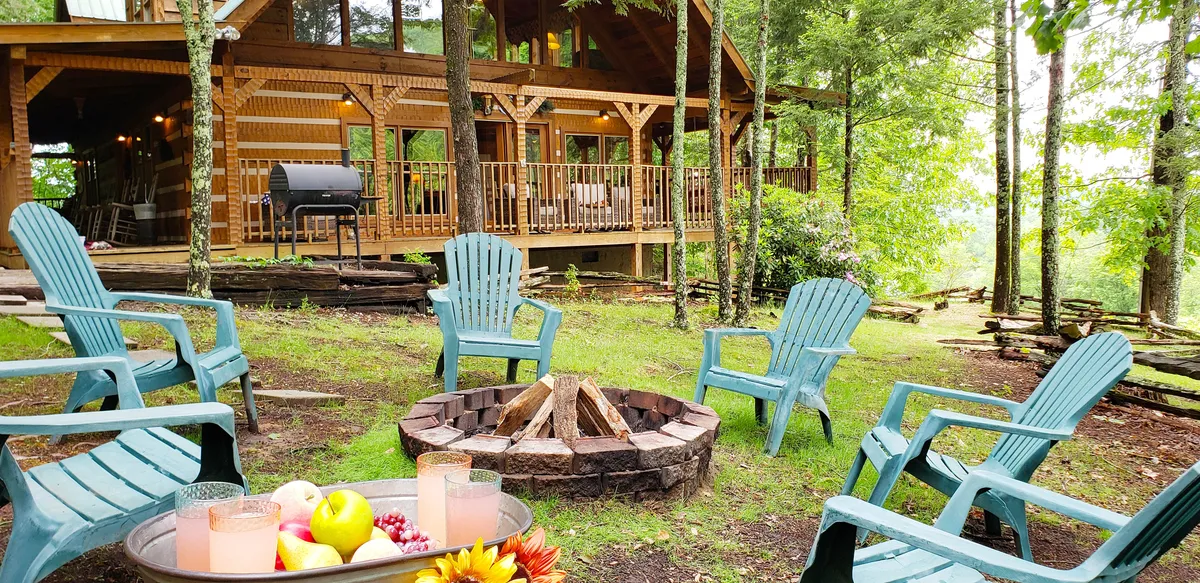 This image captures an inviting outdoor space with a fire pit surrounded by Adirondack chairs on a wooden deck, complete with a grill and nestled among trees. The cozy, communal setting is perfect for post-adventure relaxation and family gatherings, evoking the idea of sharing stories or making s'mores around the fire after a day of exploring local attractions.